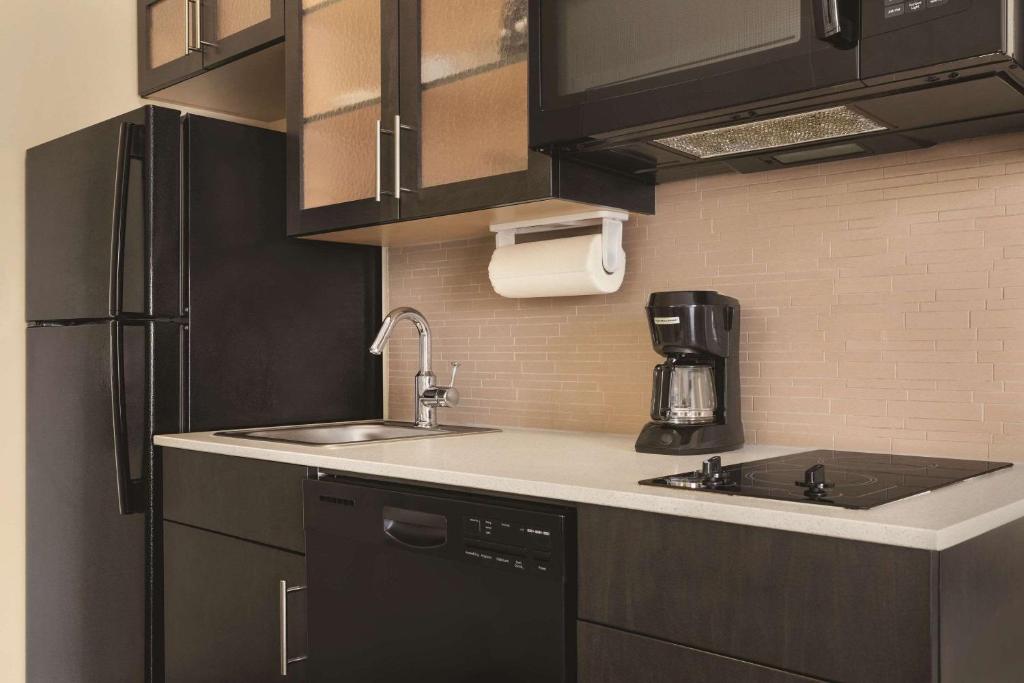 a kitchen with a sink and a refrigerator at Park Inn by Radisson, Calgary Airport North, AB in Calgary