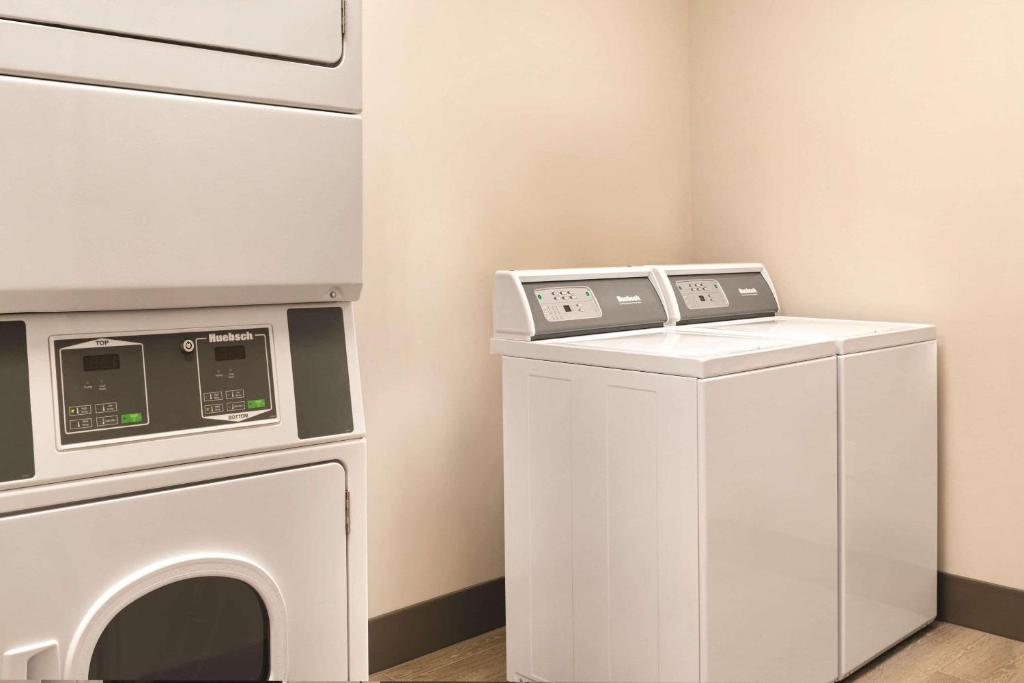 a washer and dryer in a room with a washing machine at Park Inn by Radisson, Calgary Airport North, AB in Calgary