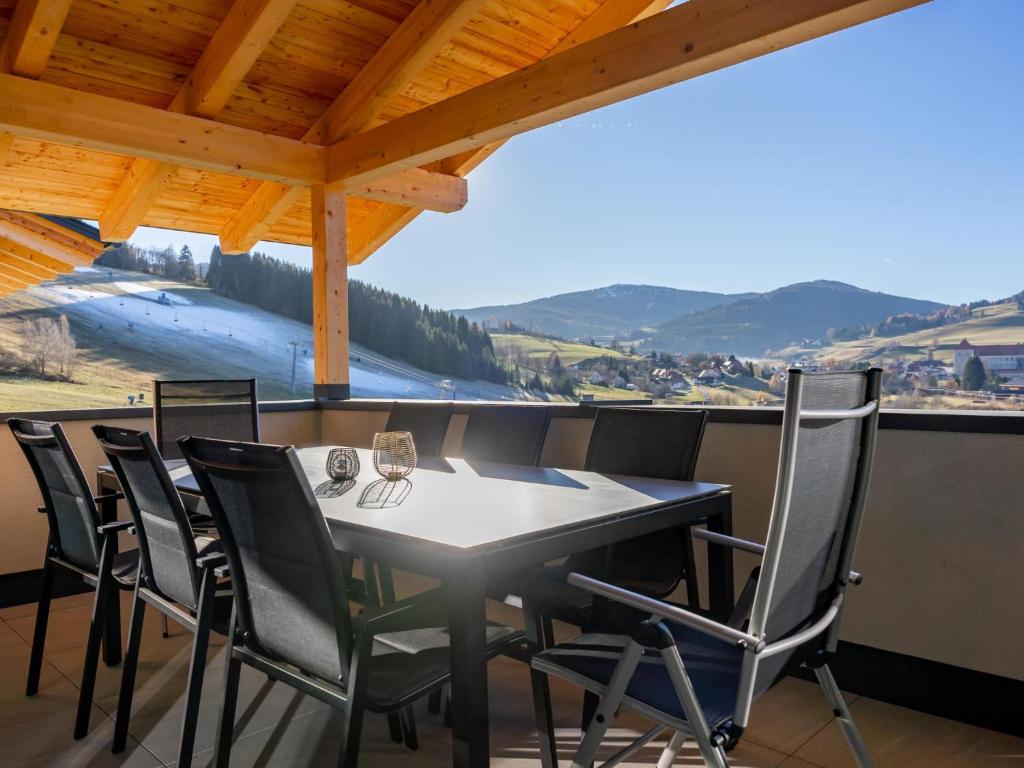 a table and chairs on a balcony with a view at Grebenzen Lodge Prinz in Sankt Lambrecht