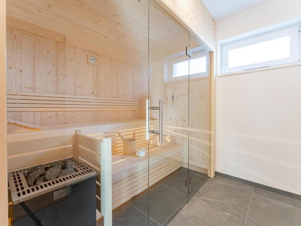 a sauna with wooden walls and a glass shower stall at Grebenzen Lodge Prinz in Sankt Lambrecht
