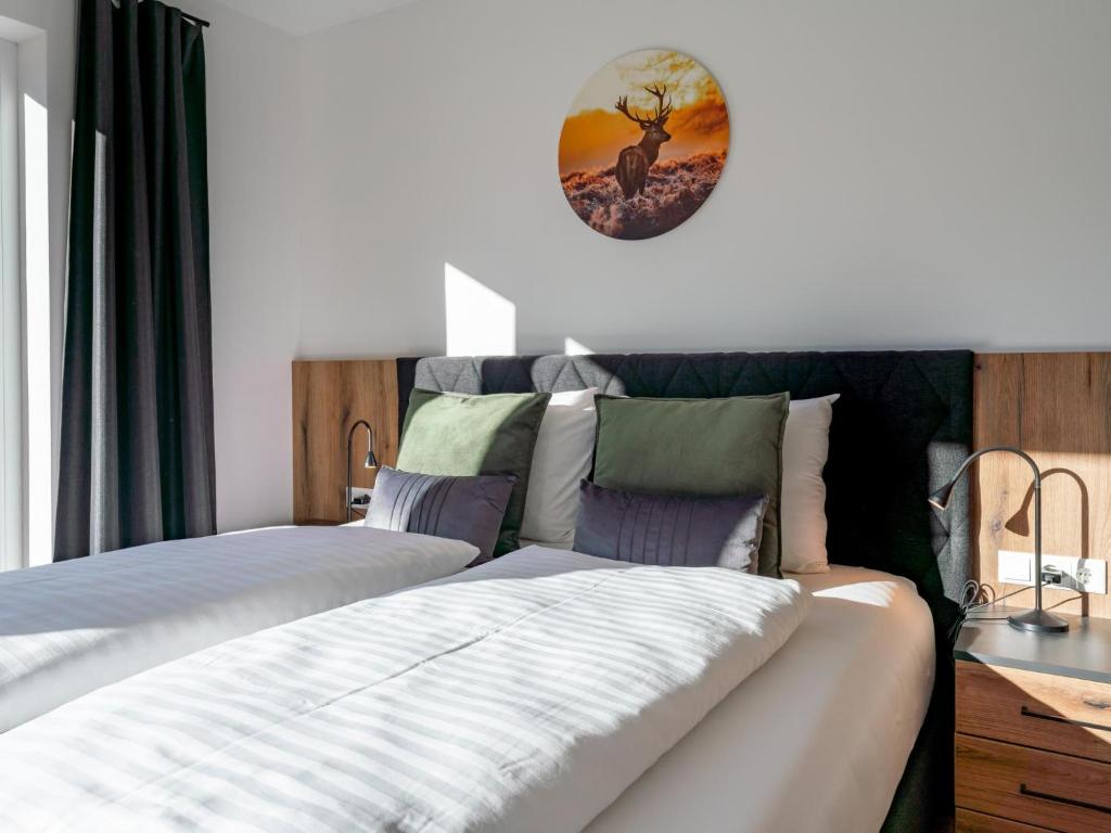 a bedroom with two beds and a clock on the wall at Grebenzen Lodge Prinz in Sankt Lambrecht