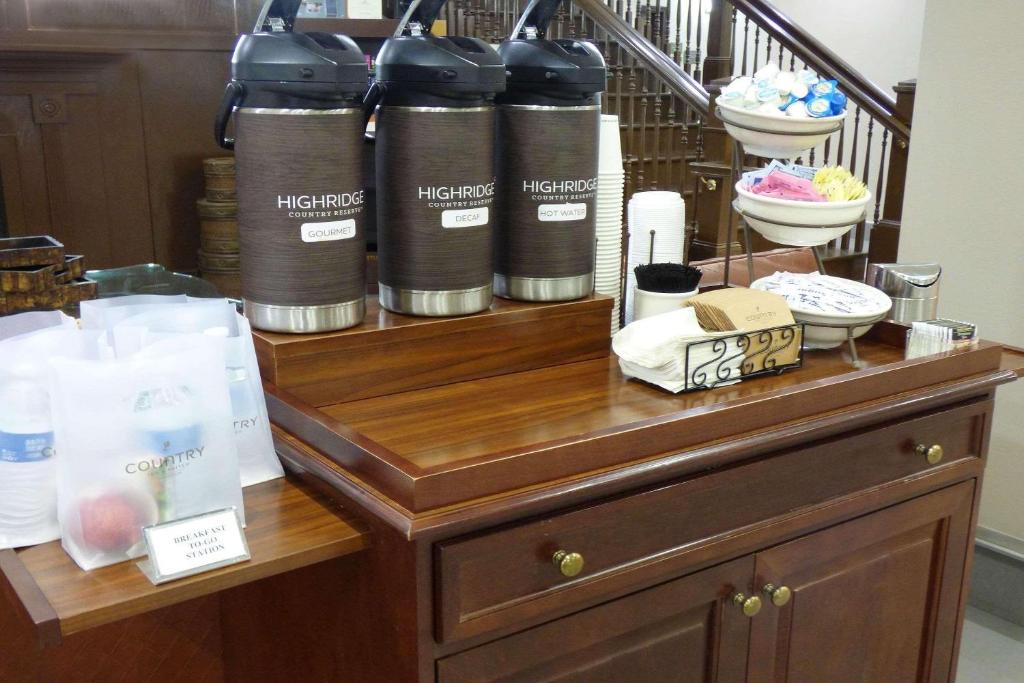 a wooden table with threelling cylinders on top of it at Country Inn & Suites by Radisson, Pensacola West, FL in Pensacola