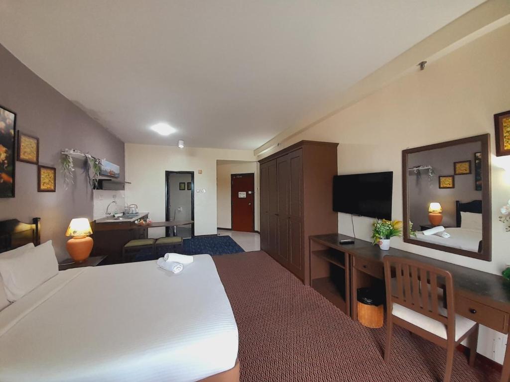 um quarto de hotel com uma cama grande e uma secretária em Rainbow paradise beach front em Tanjung Bungah