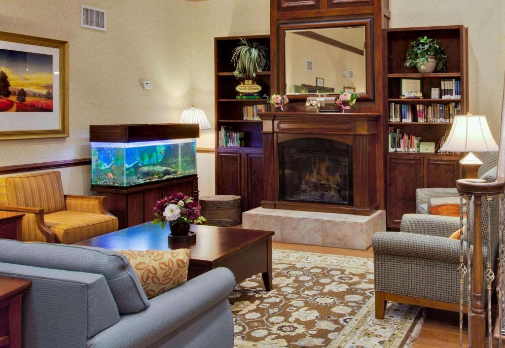 a living room with a fireplace and a fish tank at Country Inn & Suites by Radisson, Port Charlotte, FL in Port Charlotte