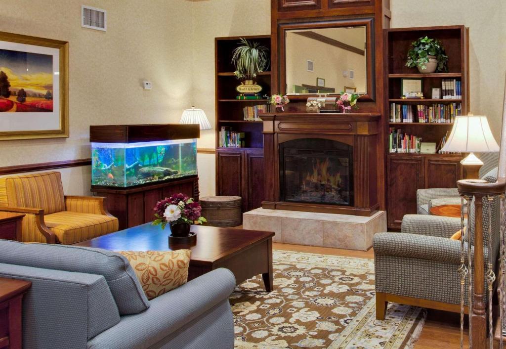 d'un salon avec une cheminée et un aquarium. dans l'établissement Country Inn & Suites by Radisson, Port Charlotte, FL, à Port Charlotte