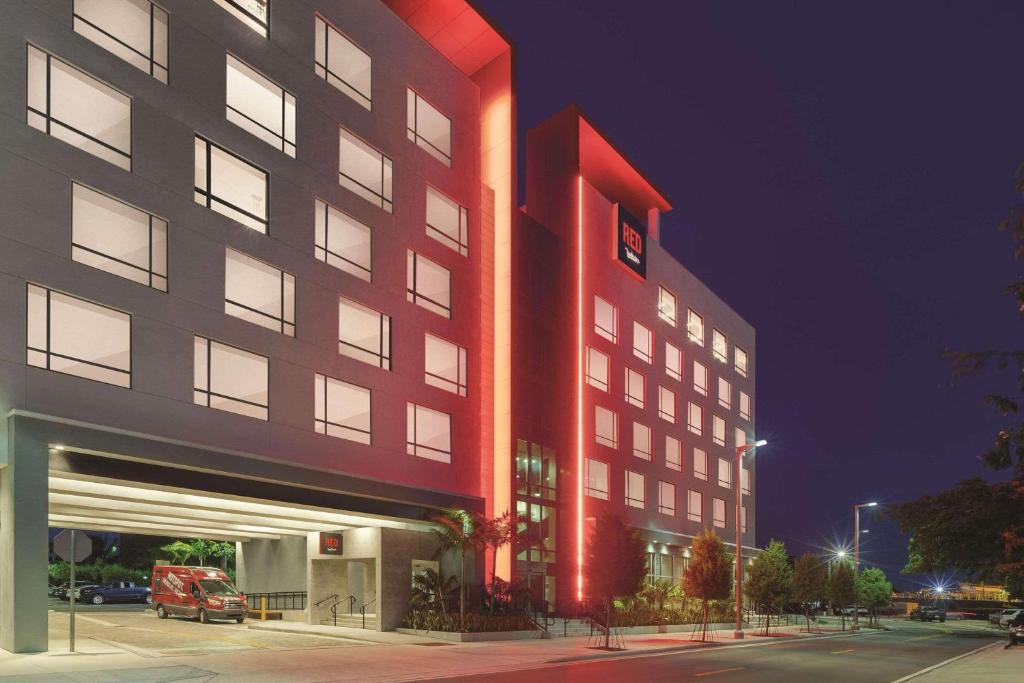 a large red building with a parking garage at night at Radisson RED Miami Airport in Miami