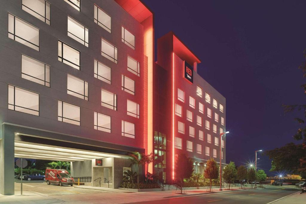 un gran edificio rojo con aparcamiento por la noche en Radisson RED Miami Airport, en Miami