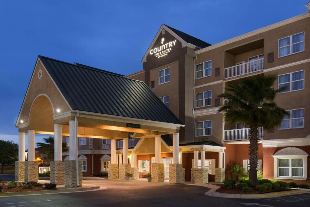 un hotel con una palmera delante en Country Inn & Suites by Radisson, Panama City Beach, FL, en Panama City Beach