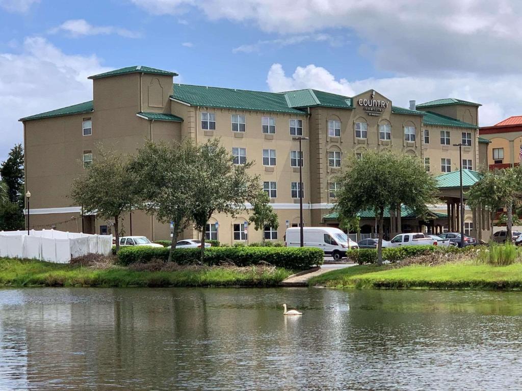 a hotel with a building next to a body of water at Country Inn & Suites by Radisson, Jacksonville West, FL in Jacksonville