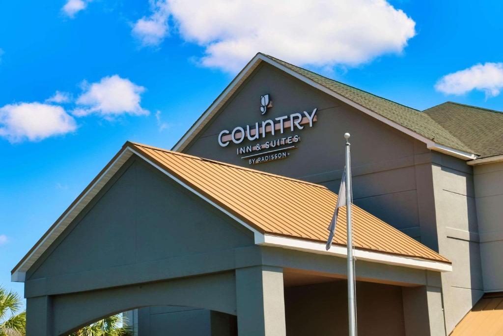 a building with acourtney insurance sign on top of it at Country Inn & Suites by Radisson, Savannah Gateway, GA in Savannah