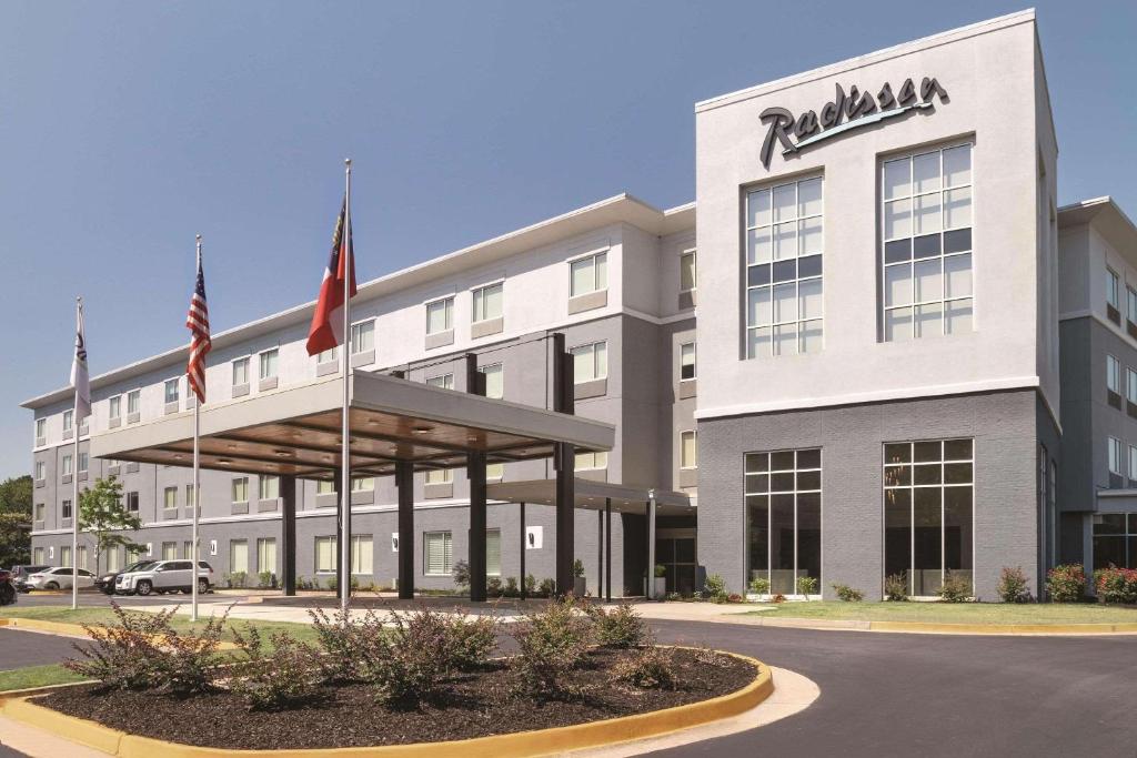 an office building with two flags in front of it at Radisson Hotel Atlanta Airport in Atlanta