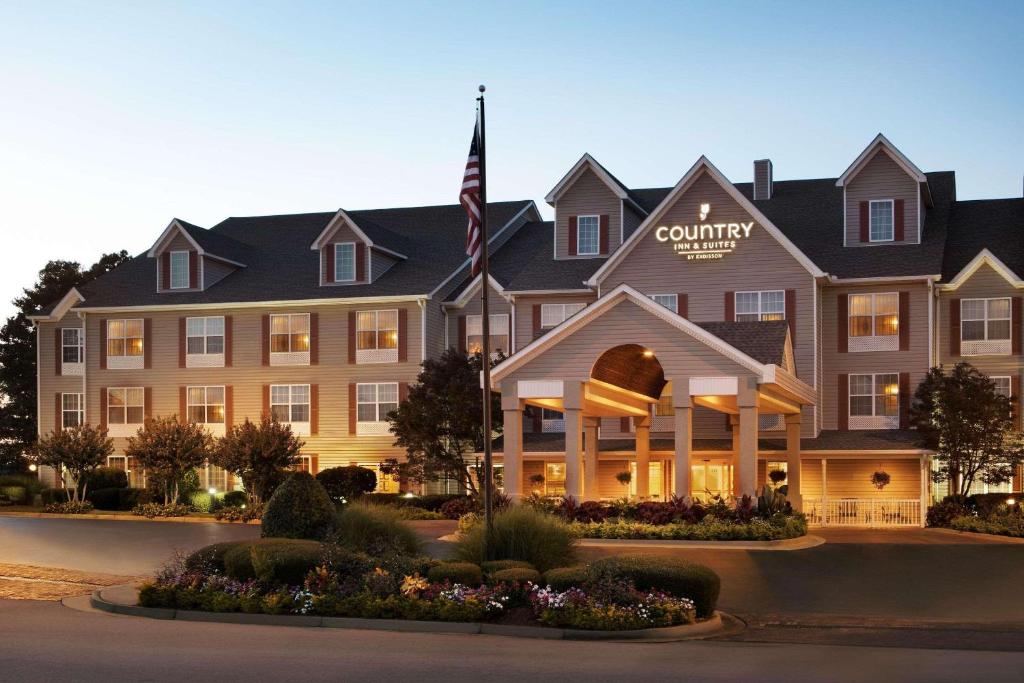 ein Hotel mit einer Flagge vor einem Gebäude in der Unterkunft Country Inn & Suites by Radisson, Atlanta Airport North, GA in Atlanta