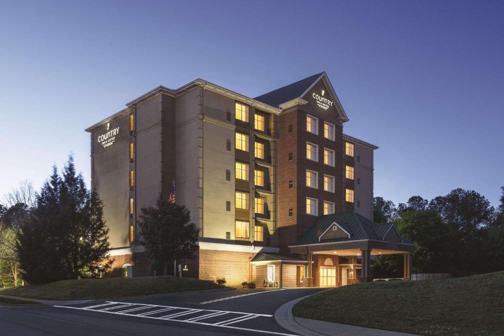un bâtiment d'hôtel avec ses lumières allumées la nuit dans l'établissement Country Inn & Suites by Radisson, Conyers, GA, à Conyers