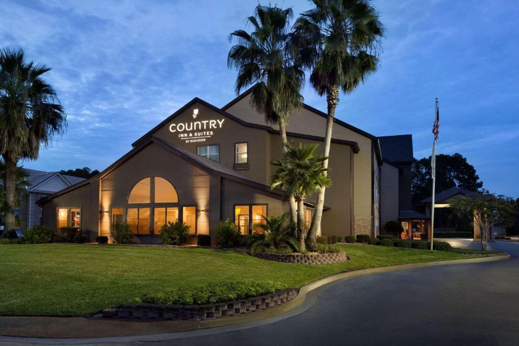 un edificio con palmeras delante en Country Inn & Suites by Radisson, Kingsland, GA, en Kingsland
