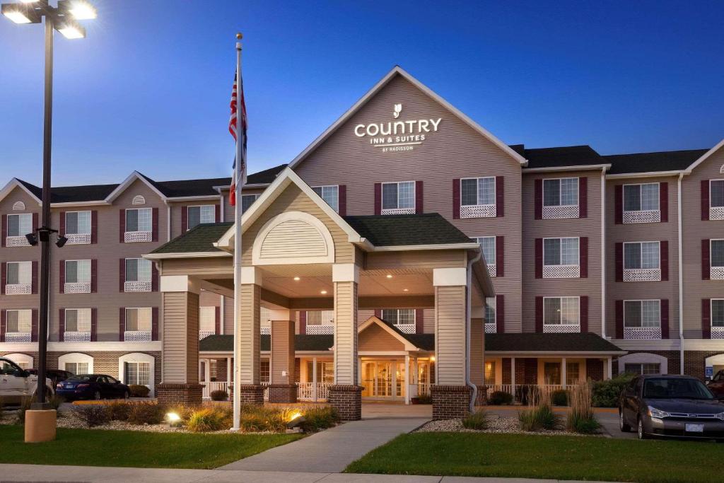 una vista frontal de un hotel con bandera en Country Inn & Suites by Radisson, Northwood, IA, en Northwood