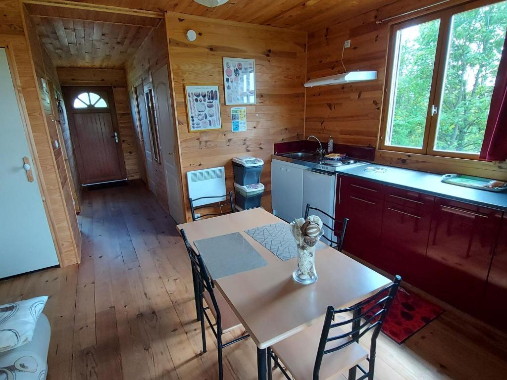 a kitchen with a table and chairs in a cabin at Gîte Velle-sur-Moselle, 3 pièces, 4 personnes - FR-1-584-108 in Velle-sur-Moselle