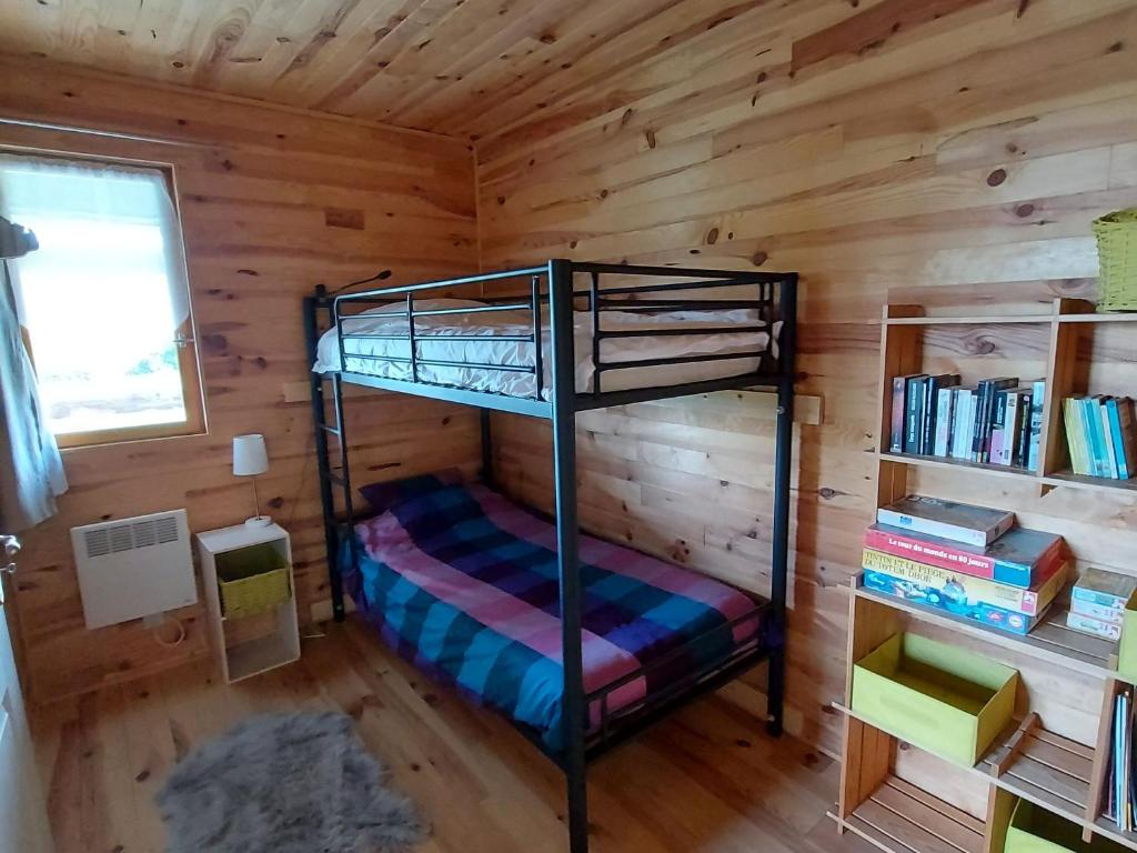a bunk bed in a log cabin with a book shelf at Gîte Velle-sur-Moselle, 3 pièces, 4 personnes - FR-1-584-108 in Velle-sur-Moselle