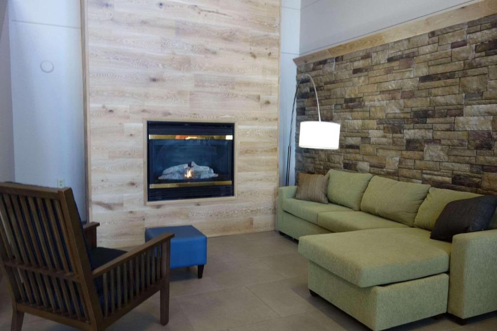 a living room with a couch and a fireplace at Country Inn & Suites by Radisson, Mason City, IA in Mason City