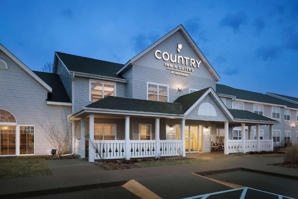 un edificio con una posada rural y suites en Country Inn & Suites by Radisson, Grinnell, IA, en Grinnell