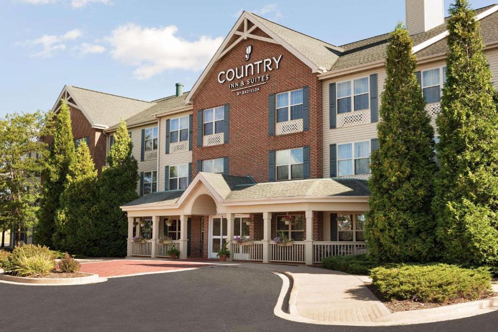 un hôtel avec un panneau à l'avant d'un bâtiment dans l'établissement Country Inn & Suites by Radisson, Sycamore, IL, à Sycamore