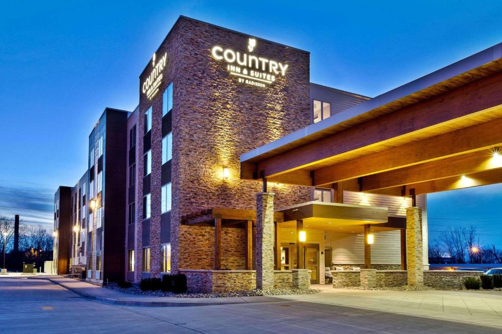 スプリングフィールドにあるCountry Inn & Suites by Radisson, Springfield, ILの建物の横に看板のあるホテル