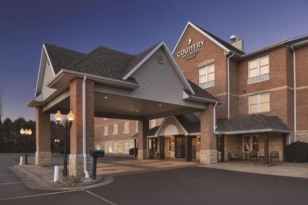 een hotelgebouw met een parkeerplaats ervoor bij Country Inn & Suites by Radisson, Galena, IL in Galena