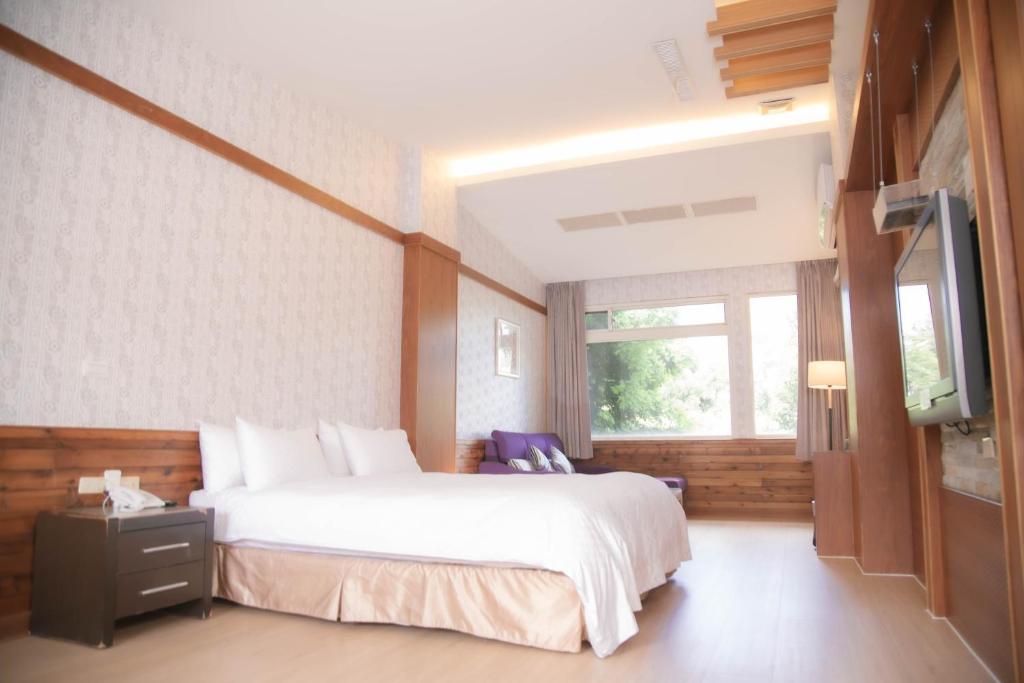 a bedroom with a large bed and a television at Guanziling Lin Kuei Yuan Hot Spring Resort in Baihe