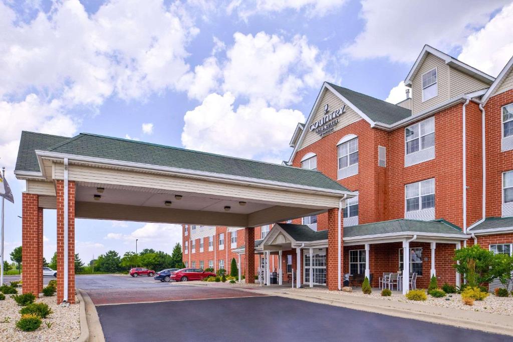 ein großes rotes Backsteingebäude mit einem Parkplatz in der Unterkunft Country Inn & Suites by Radisson, Tinley Park, IL in Tinley Park