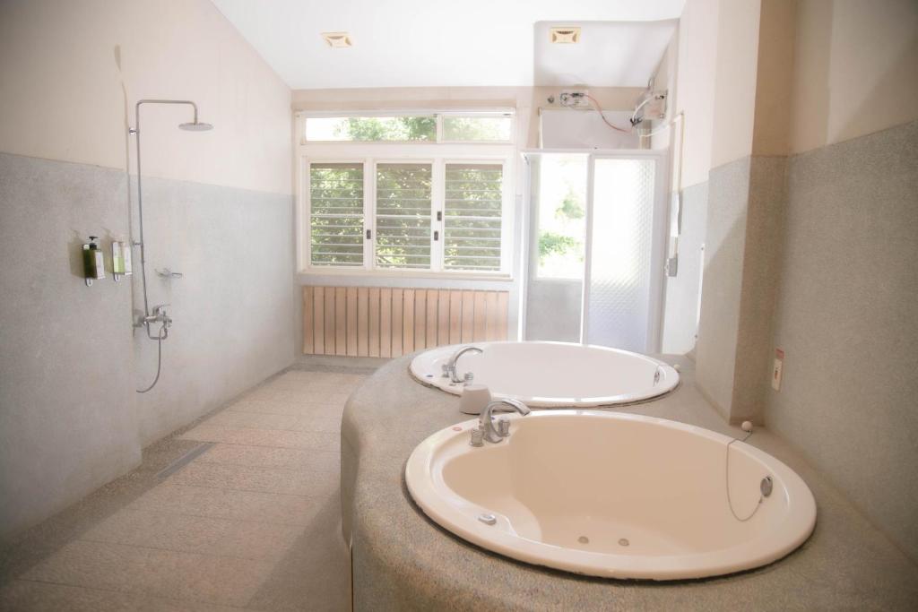 a bathroom with a large sink and a shower at Guanziling Lin Kuei Yuan Hot Spring Resort in Baihe
