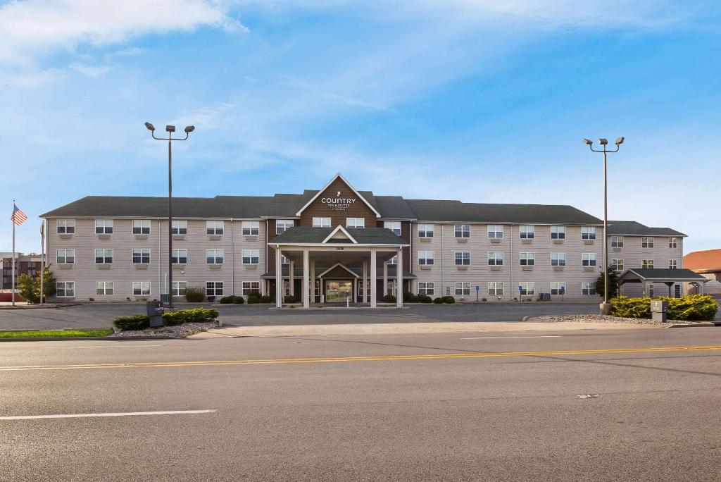 un gran edificio con un estacionamiento delante de él en Country Inn & Suites by Radisson, Marion, IL en Marion