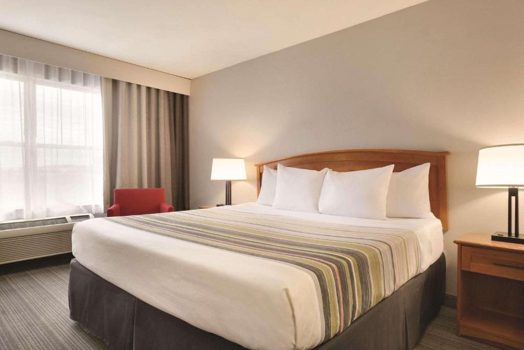 een hotelkamer met een groot bed en een raam bij Country Inn & Suites by Radisson, Portage, IN in Portage