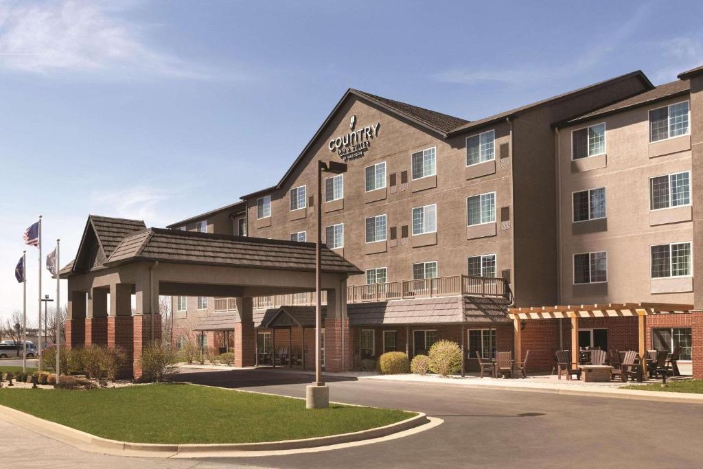 Country Inn & Suites by Radisson, Indianapolis Airport South, IN في انديانابوليس: مبنى الفندق وامامه شرفة