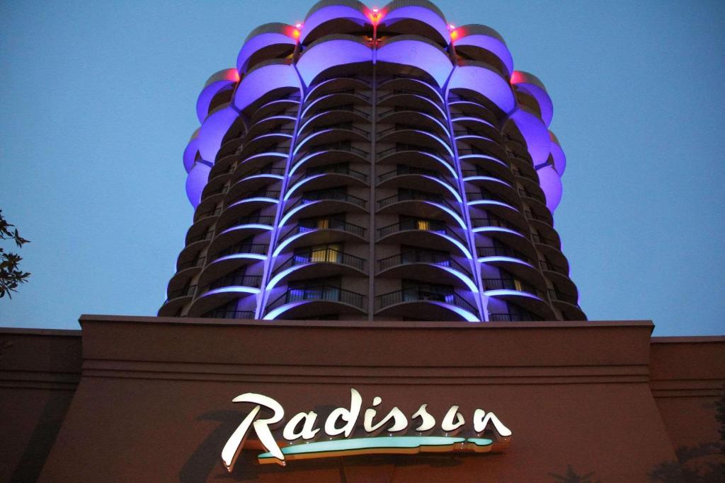 un grand bâtiment avec un panneau d'hôtel devant lui dans l'établissement Radisson Hotel Cincinnati Riverfront, à Covington