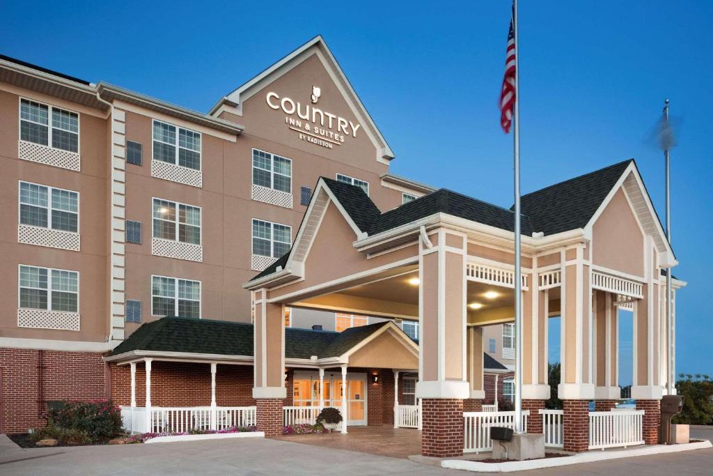 a front view of a hotel with a flag at Country Inn & Suites by Radisson, Bowling Green, KY in Bowling Green