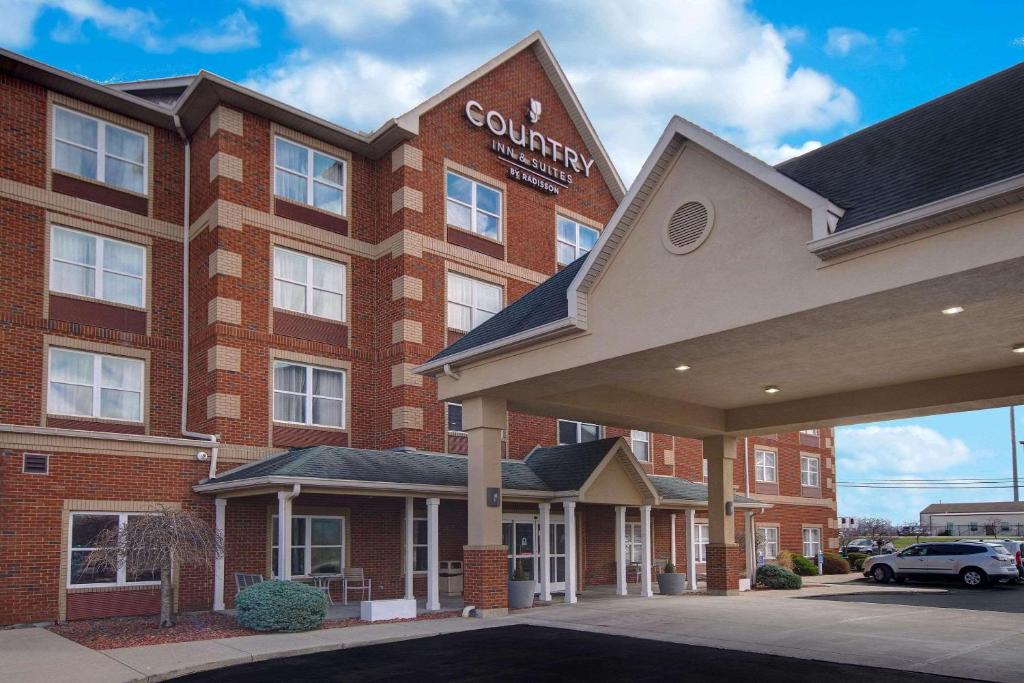 a courtyard hotel with a car parked in front of it at Country Inn & Suites by Radisson, Cincinnati Airport, KY in Hebron