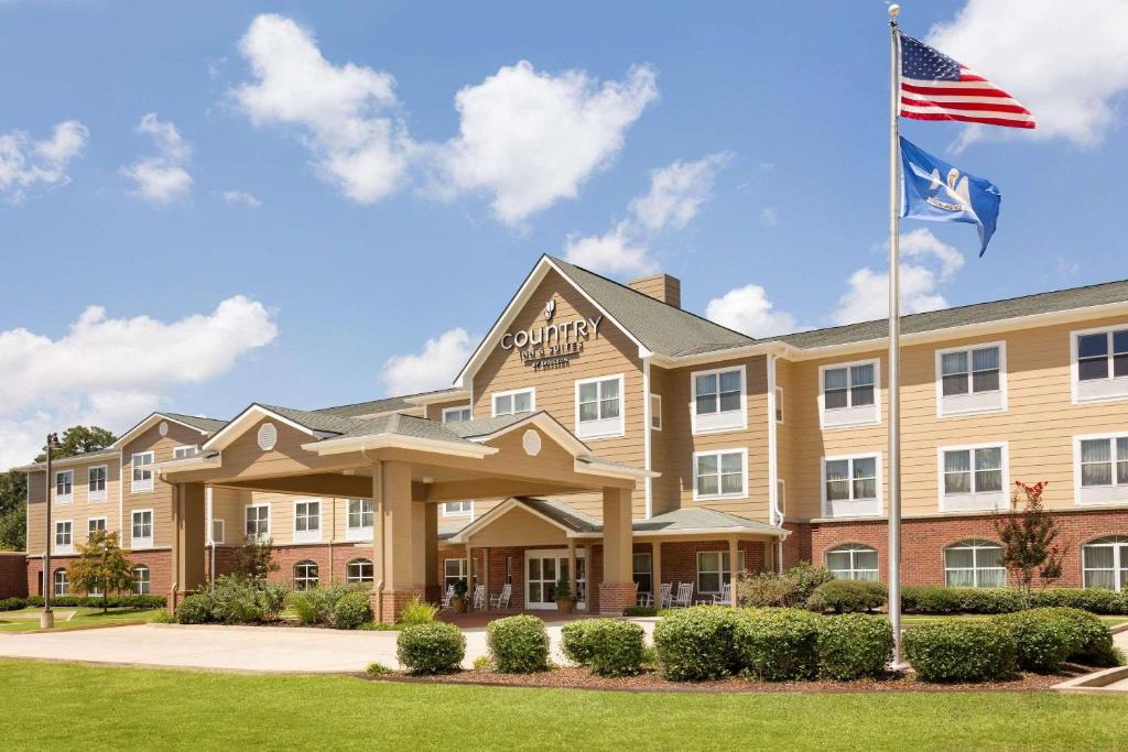 an image of the front of a hotel with an american flag at Country Inn & Suites by Radisson, Pineville, LA in Pineville