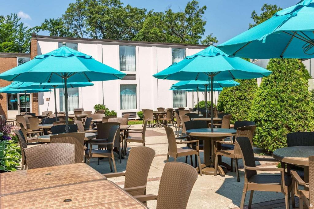 a group of tables and chairs with blue umbrellas at Country Inn & Suites by Radisson, Traverse City, MI in Traverse City