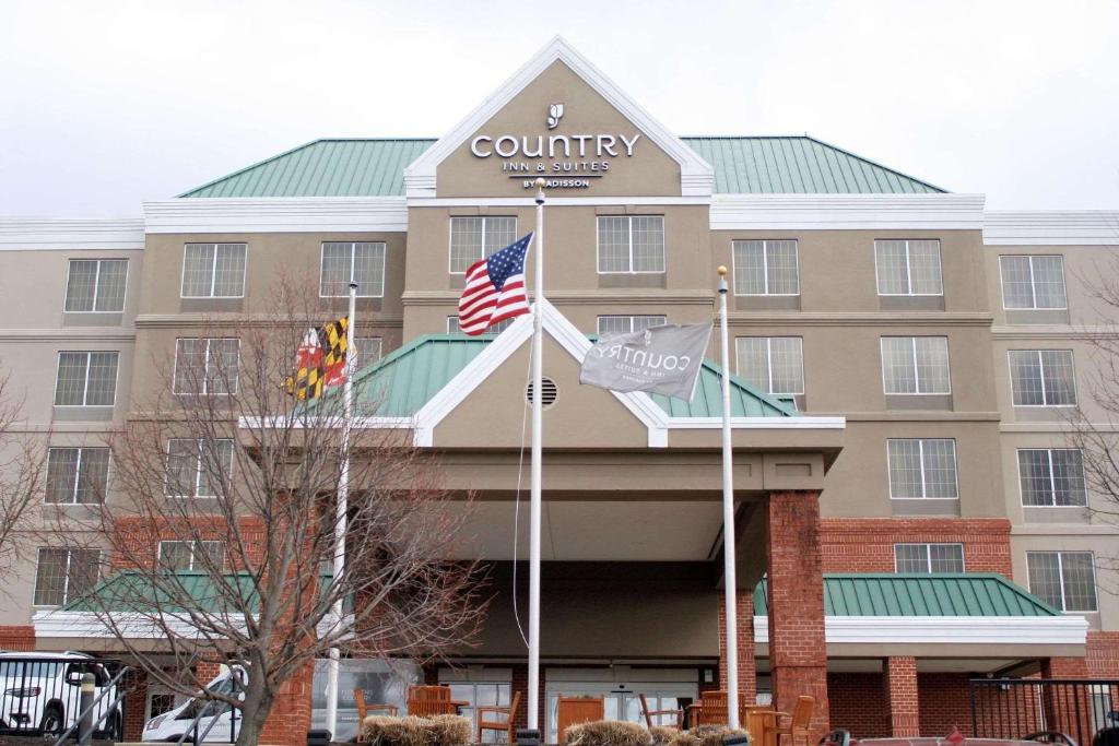 リンティカム・ハイツにあるCountry Inn & Suites by Radisson, BWI Airport Baltimore , MDの旗の前の建物