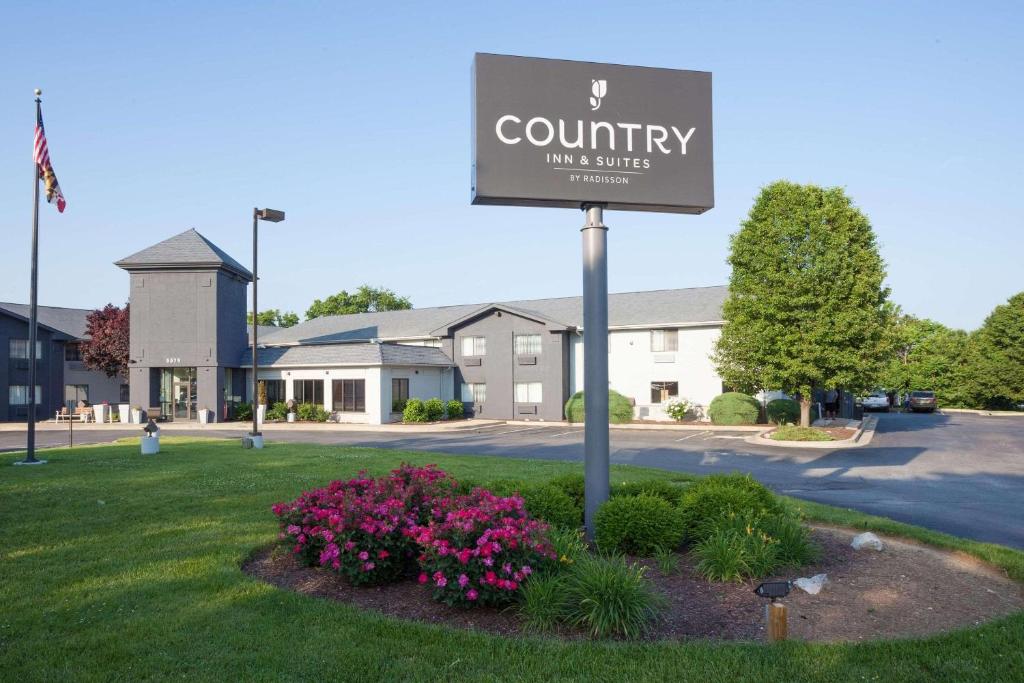 Country Inn & Suites by Radisson, Frederick, MD في فريدريك: علامة لاجنحة نزل ريفية في ساحة