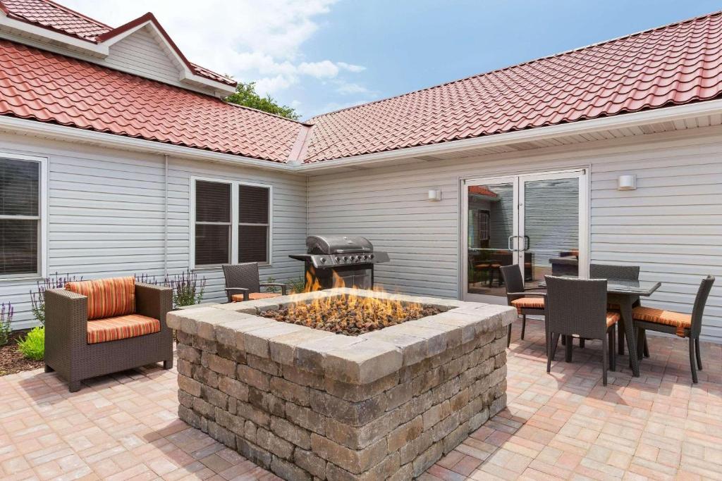 a patio with a fire pit and a table and chairs at Country Inn & Suites by Radisson, Holland, MI in Holland