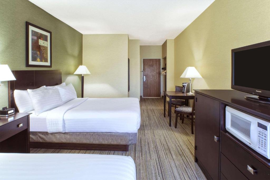 a hotel room with two beds and a flat screen tv at Country Inn & Suites by Radisson Benton Harbor-St Joseph MI in Benton Harbor