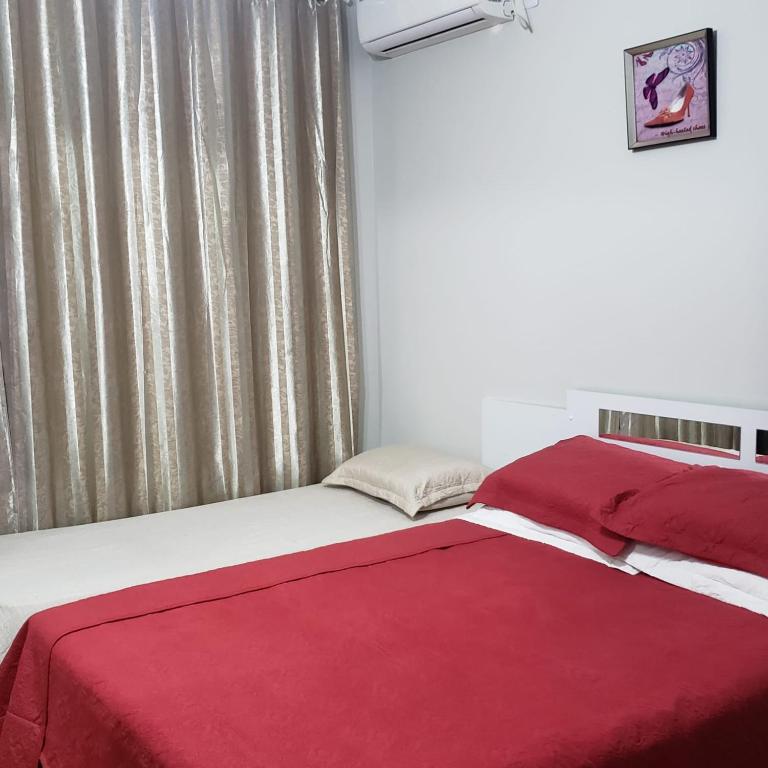 Gringo Habitación Casa 2 في ساو غابرييل: غرفة نوم بسرير وبطانية حمراء