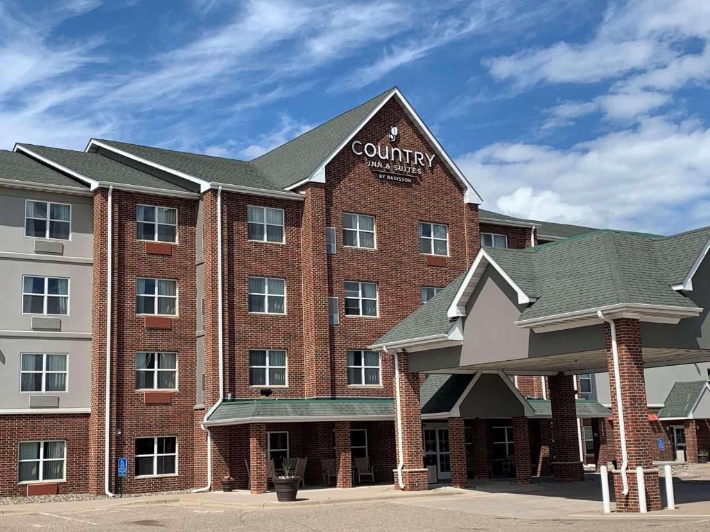 a large red brick building with a company sign on it at Country Inn & Suites by Radisson, Shoreview, MN in Mounds View