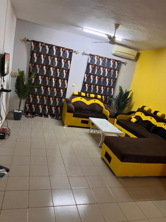 ein Wohnzimmer mit 2 Sofas und einem Tisch in der Unterkunft Ouedraogo Property Management in Ouagadougou