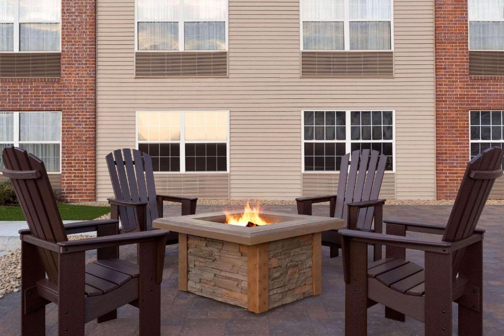 eine Terrasse mit 2 Stühlen und einer Feuerstelle in der Unterkunft Country Inn & Suites by Radisson, Rochester South, MN in Rochester