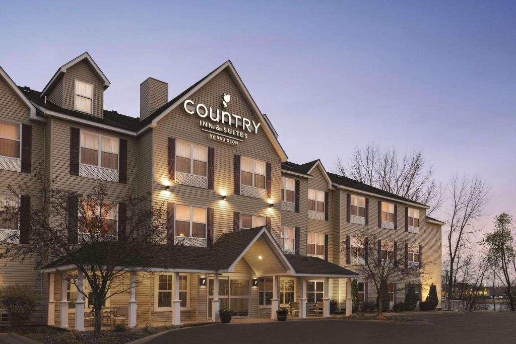 un edificio con un cartel en la parte delantera en Country Inn & Suites by Radisson, Forest Lake, MN en Forest Lake