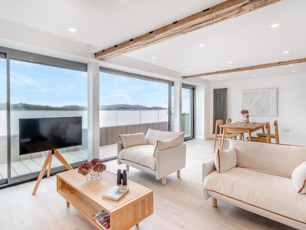 a living room with large windows and a large tv at Beach Haven in Arnside