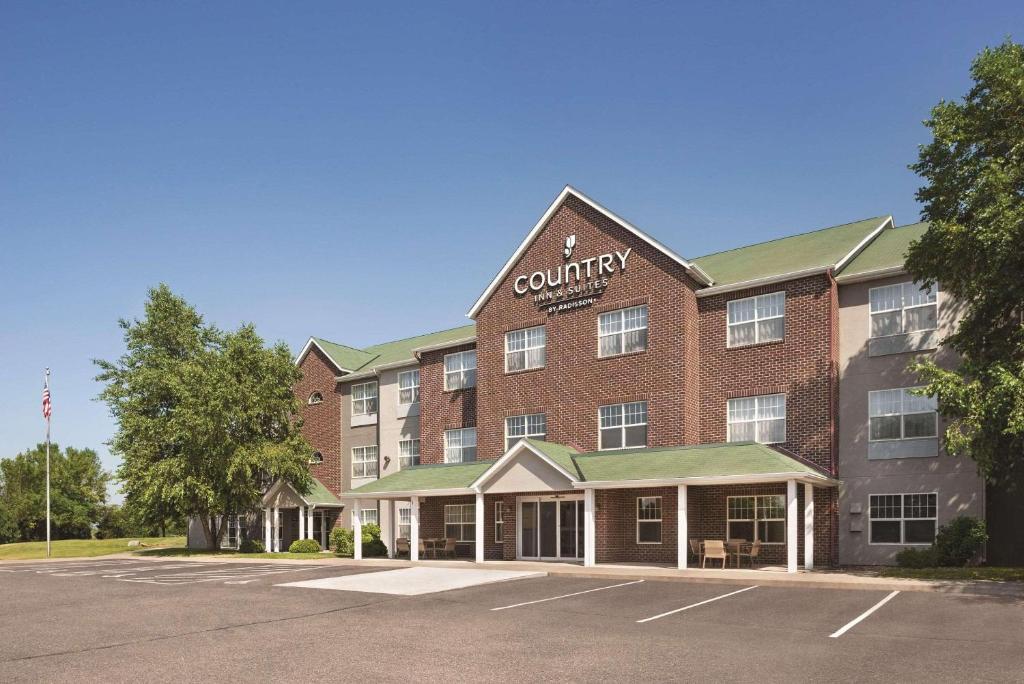 a large red brick building with a county hotel at Country Inn & Suites by Radisson, Cottage Grove, MN in Cottage Grove