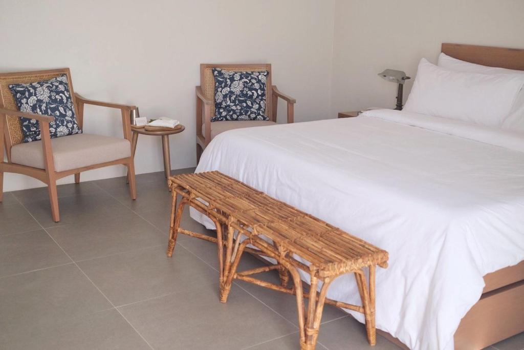 sypialnia z łóżkiem, stołem i krzesłami w obiekcie Aginana Villas w mieście san juan la union