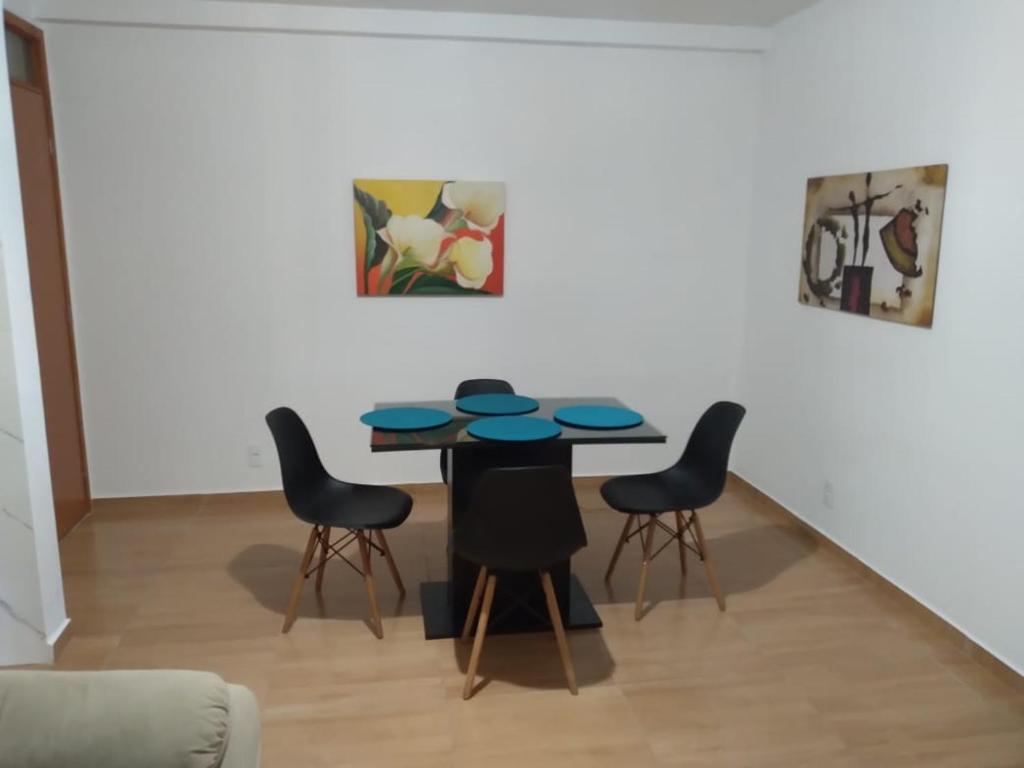 Apartamento 3/4, 1 suíte Vog Atlântico في ايليوس: غرفة طعام مع طاولة وأربعة كراسي